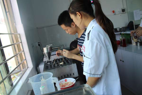 在煌旗学做章鱼小丸子的学生培训中